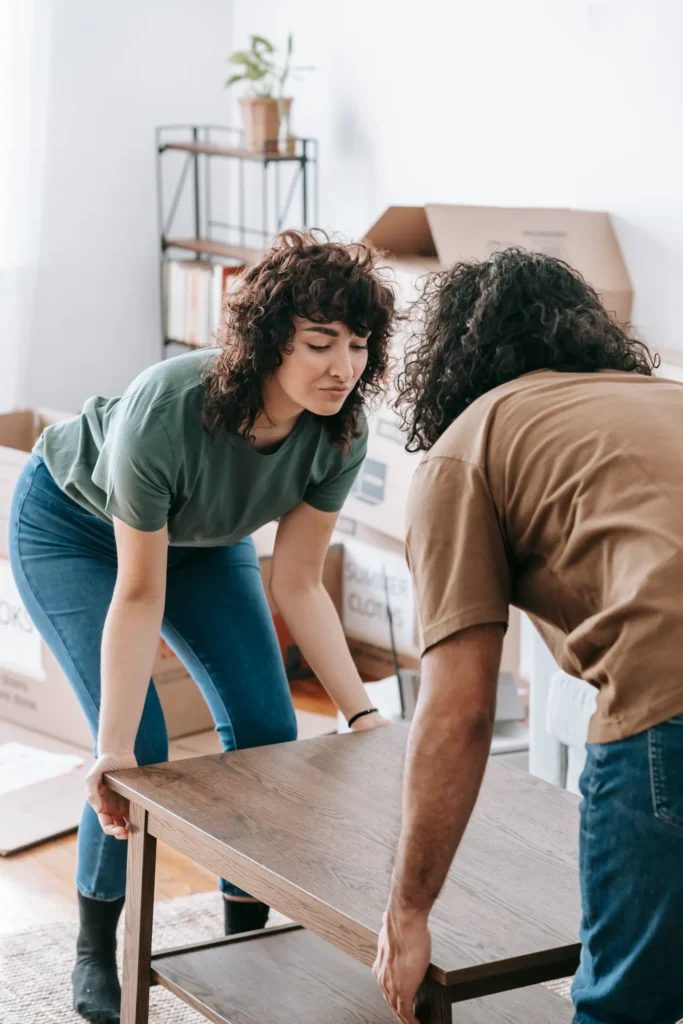 Two people lifting a newly assembled table
