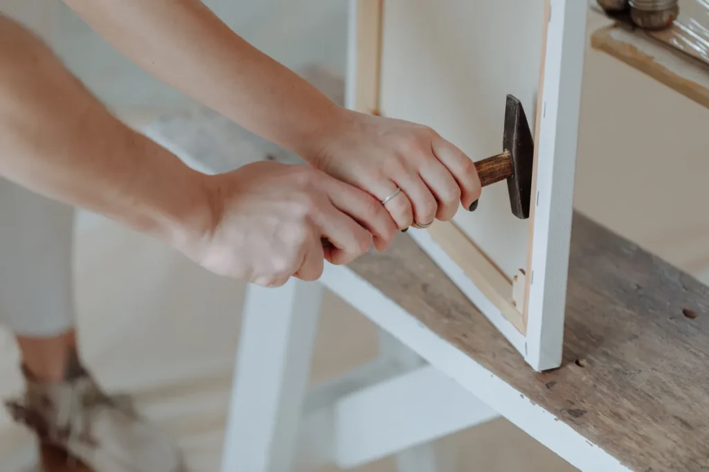 Hand tightening a bolt on a white bed frame