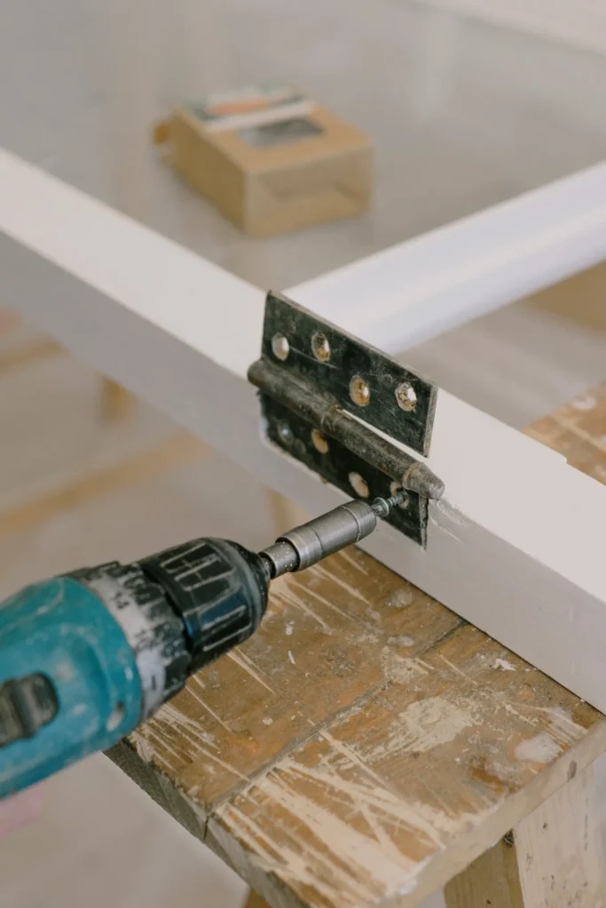 Drill fixing a metal bracket to a frame