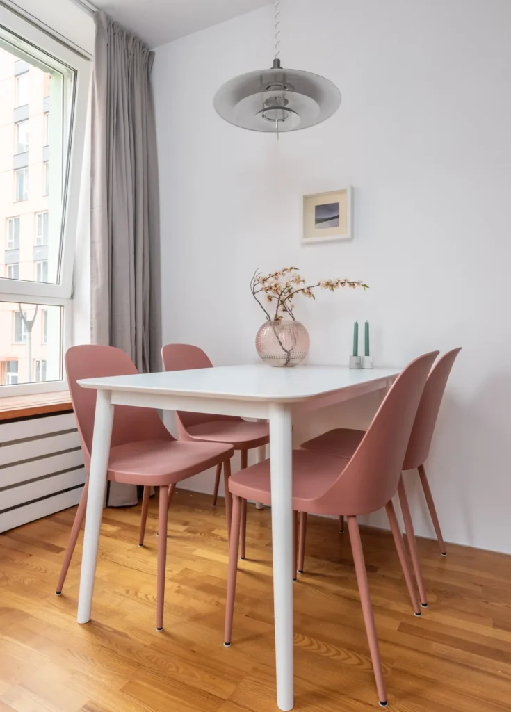 Pink chairs around a white dining table