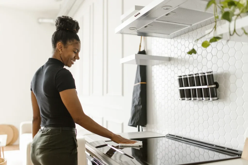 Woman wiping down a modern kitchen counter