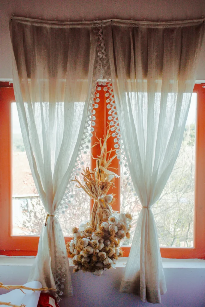 Sheer curtains on a rod at a sunny window