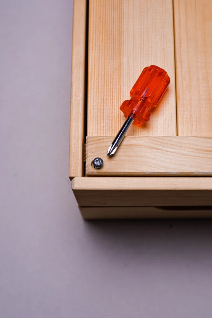 Screwdriver on a wooden drawer during assembly