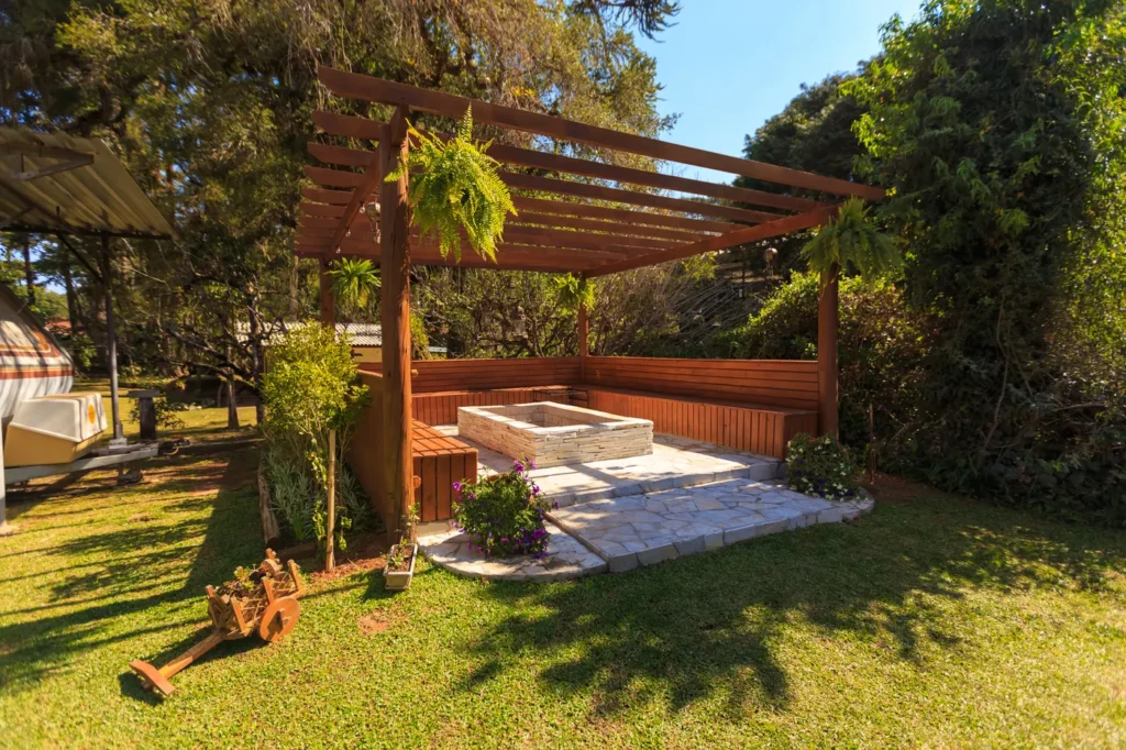 Wooden pergola with seating in a sunny garden