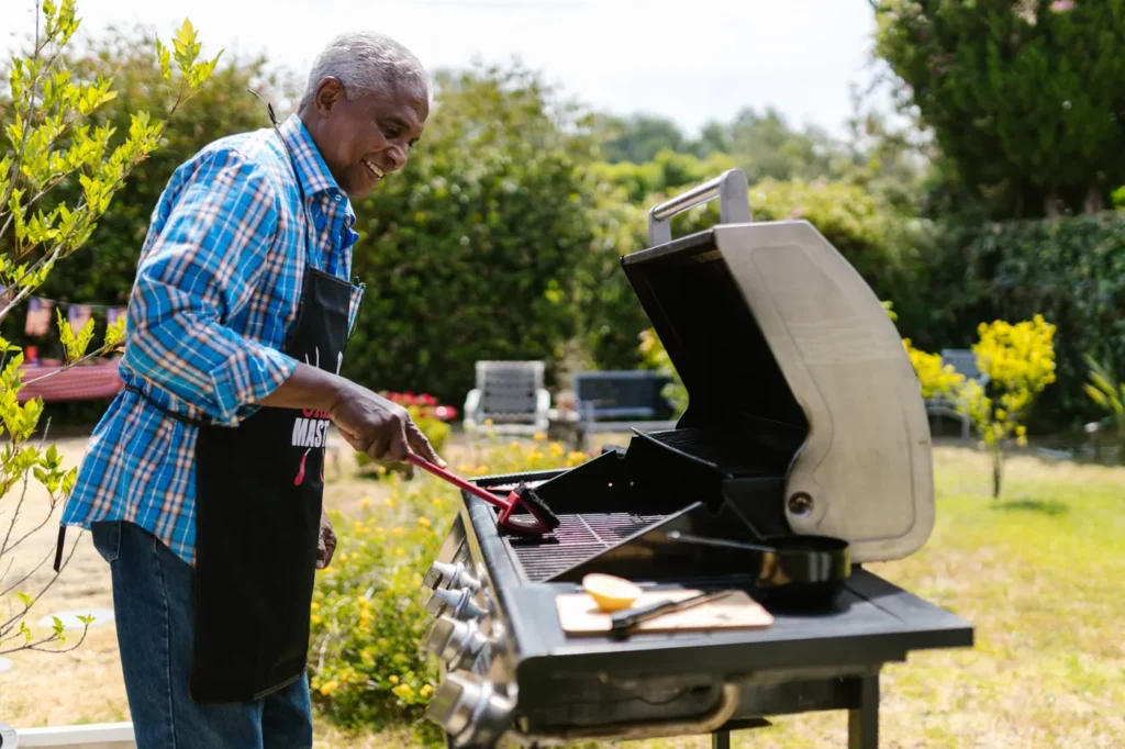 Man cooking on a gas grill in a backyard