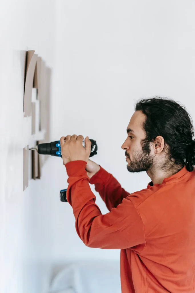 Man drilling into a wall to mount a fixture