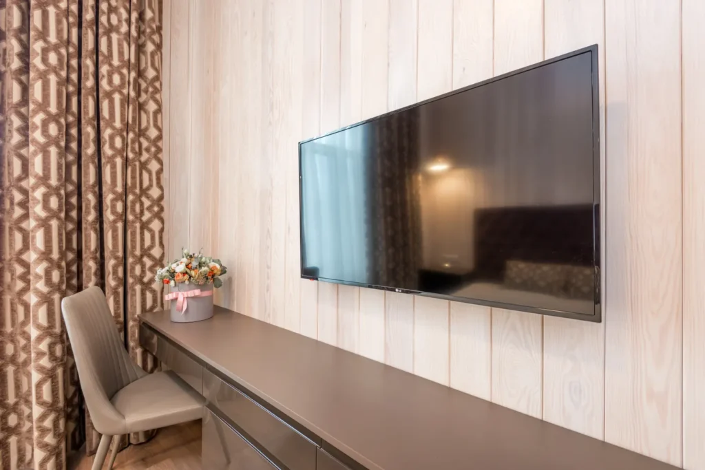 Flat-screen TV mounted on a wood-panelled living room wall