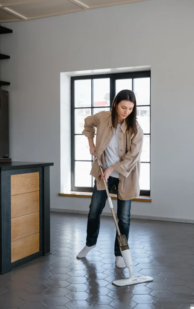 Woman mopping the floor of an empty apartment